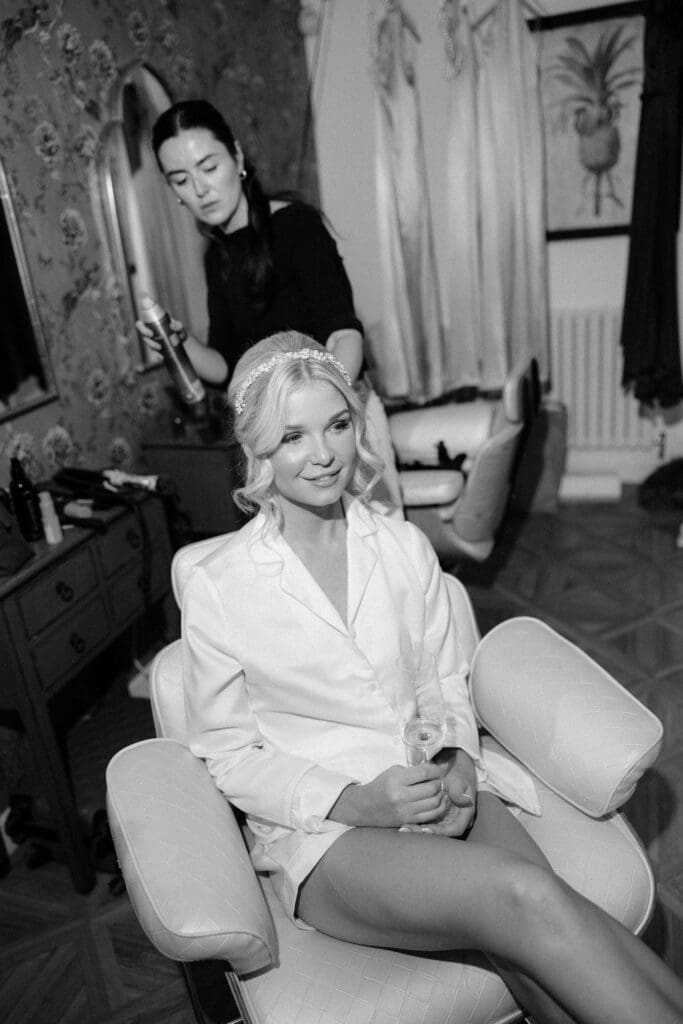 Black and white portrait of bride seated during calm wedding morning preparations.