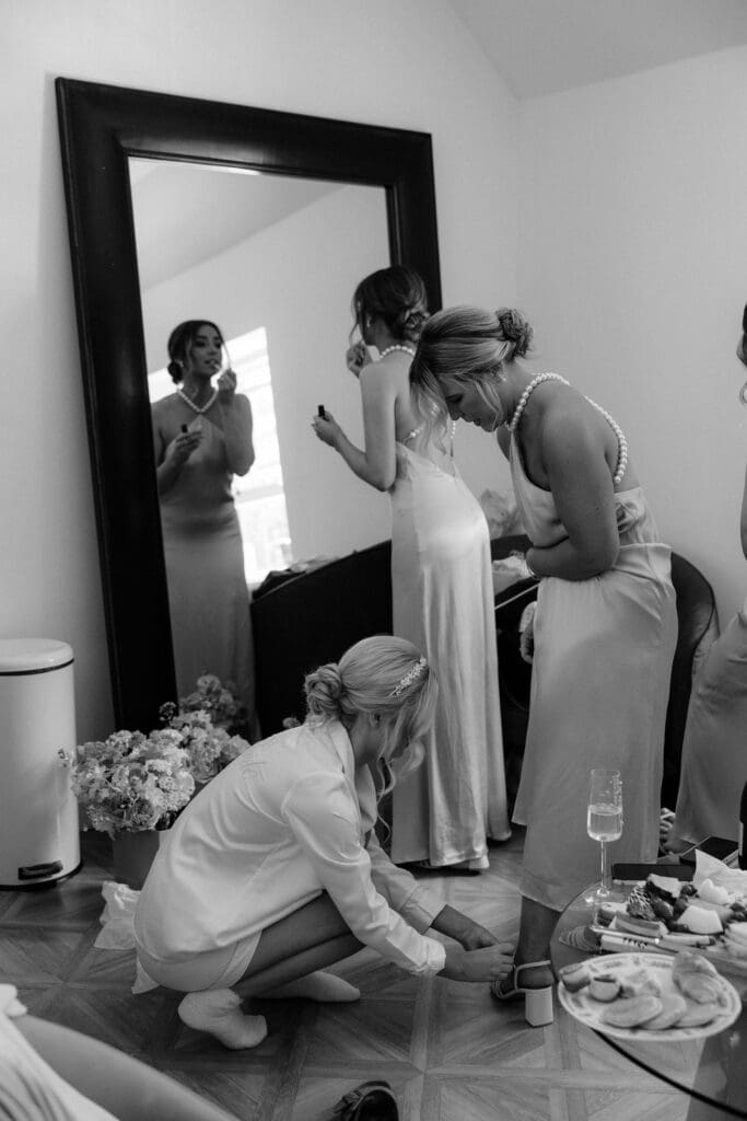 Black and white candid moment of bridal party getting ready at Broxmouth Courtyard