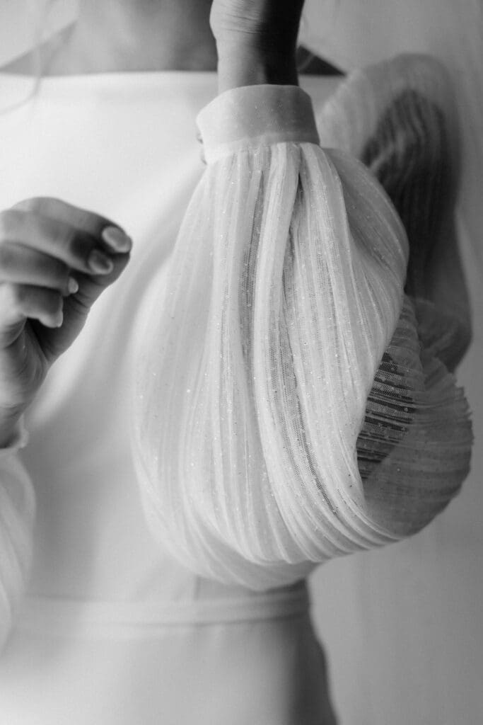 Close-up of bride’s sheer sleeve detail on wedding dress