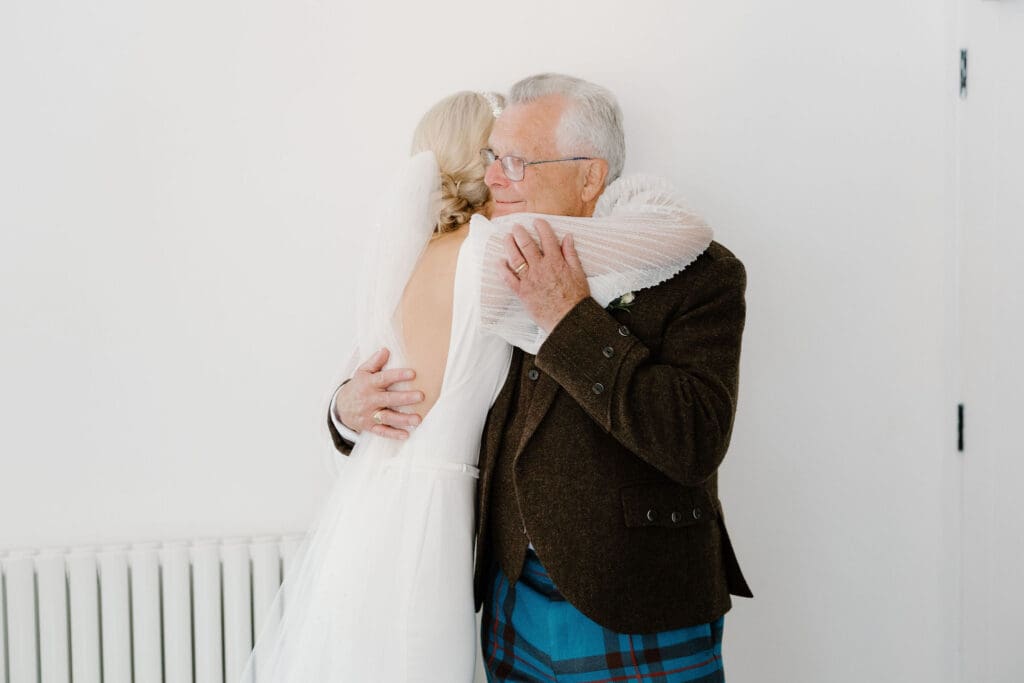 Bride sharing an emotional hug with dad before the ceremony.