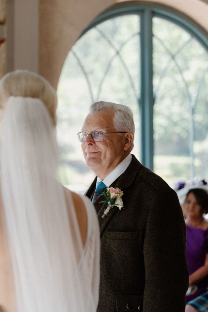 Emotional moment as the bride stands facing dad during the ceremony.