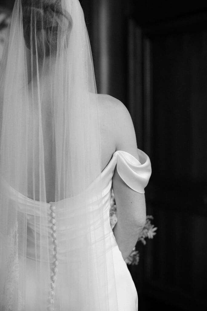 Bride seen from behind in her wedding dress and veil during preparations at The Edinburgh Grand waiting for first look with dad