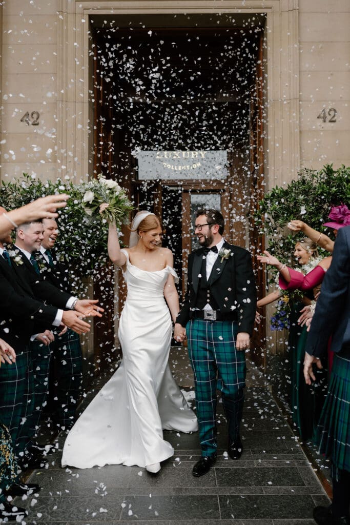 Bride and groom walking through confetti at The Edinburgh Grand wedding