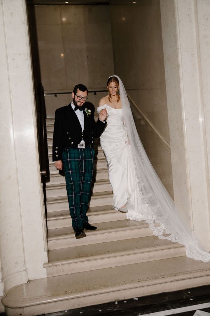 Bride and groom walking down the steps at The Edinburgh Grand wedding venue
