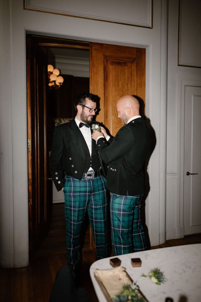Groom adjusting his tie during wedding morning preparations at The Edinburgh Grand
